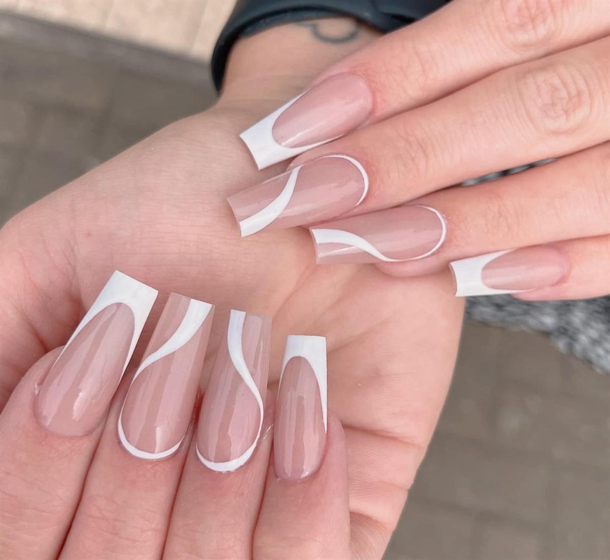 Long nude coffin nails with crisp white French tips and white swirl outlines