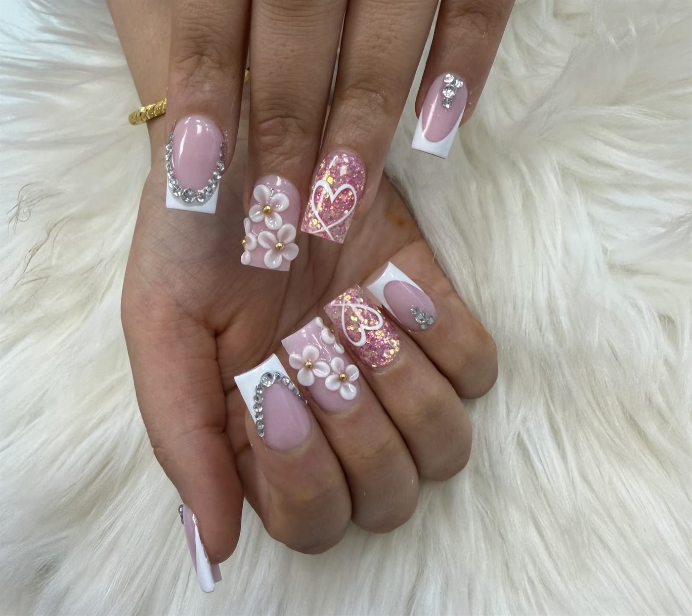 Long pink French tip nails with 3D white flowers, rhinestones and gold heart art